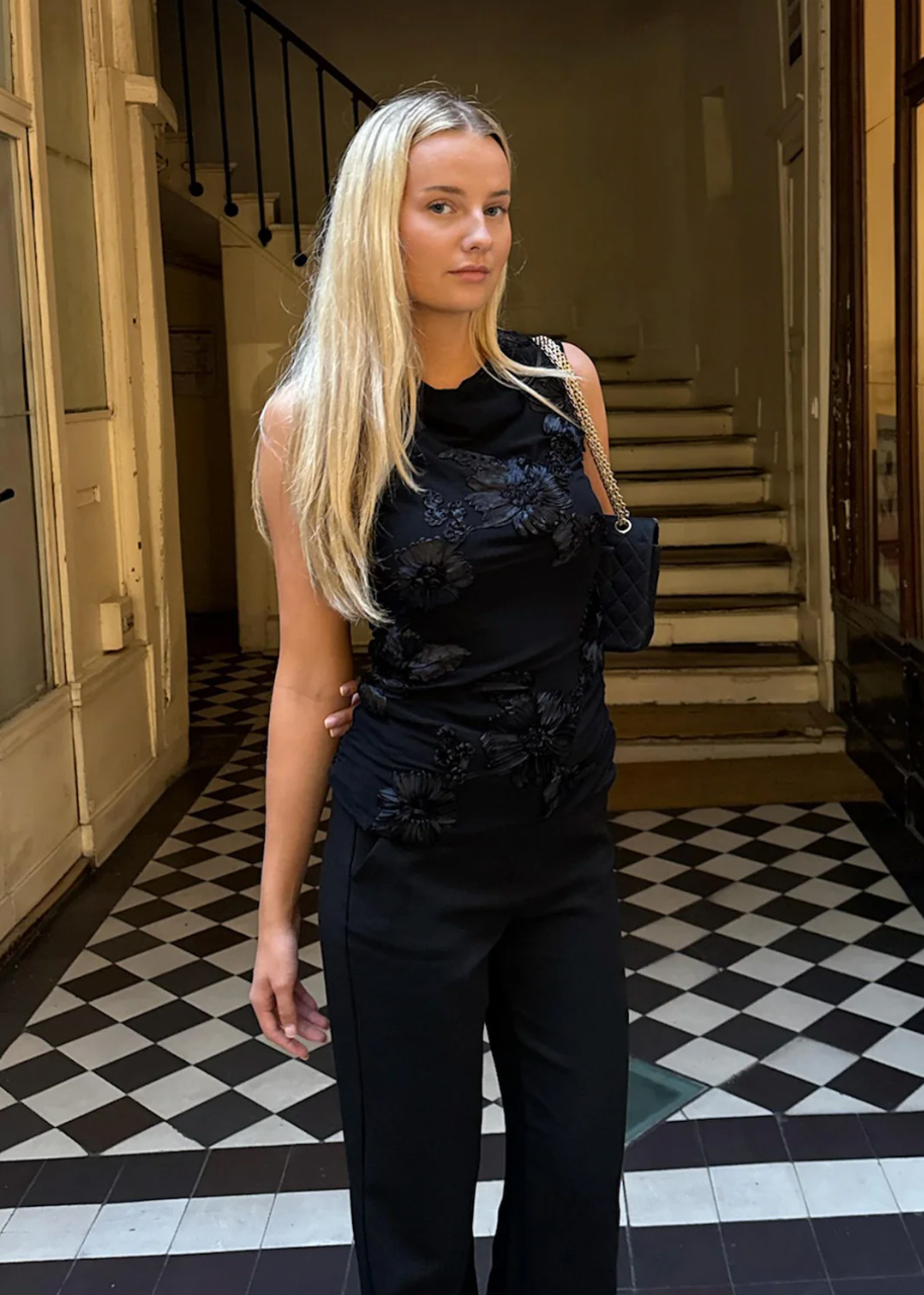 Svart topp med blomsterdetaljer