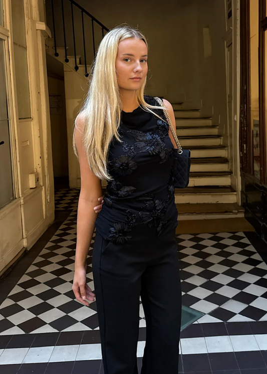 Svart topp med blomsterdetaljer